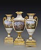 A highly important and very beautiful Classical gilt and polychrome painted porcelain armorial and topographical three-piece vase garniture from “The Meiningen Service” made by the Royal Berlin Porcelain Manufactory (K.P.M)